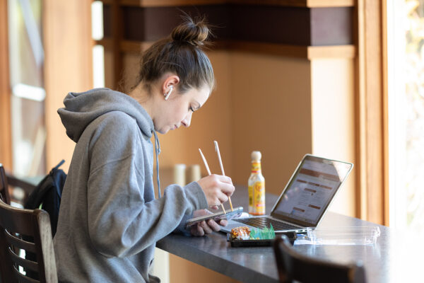 student using a laptop in a cafe