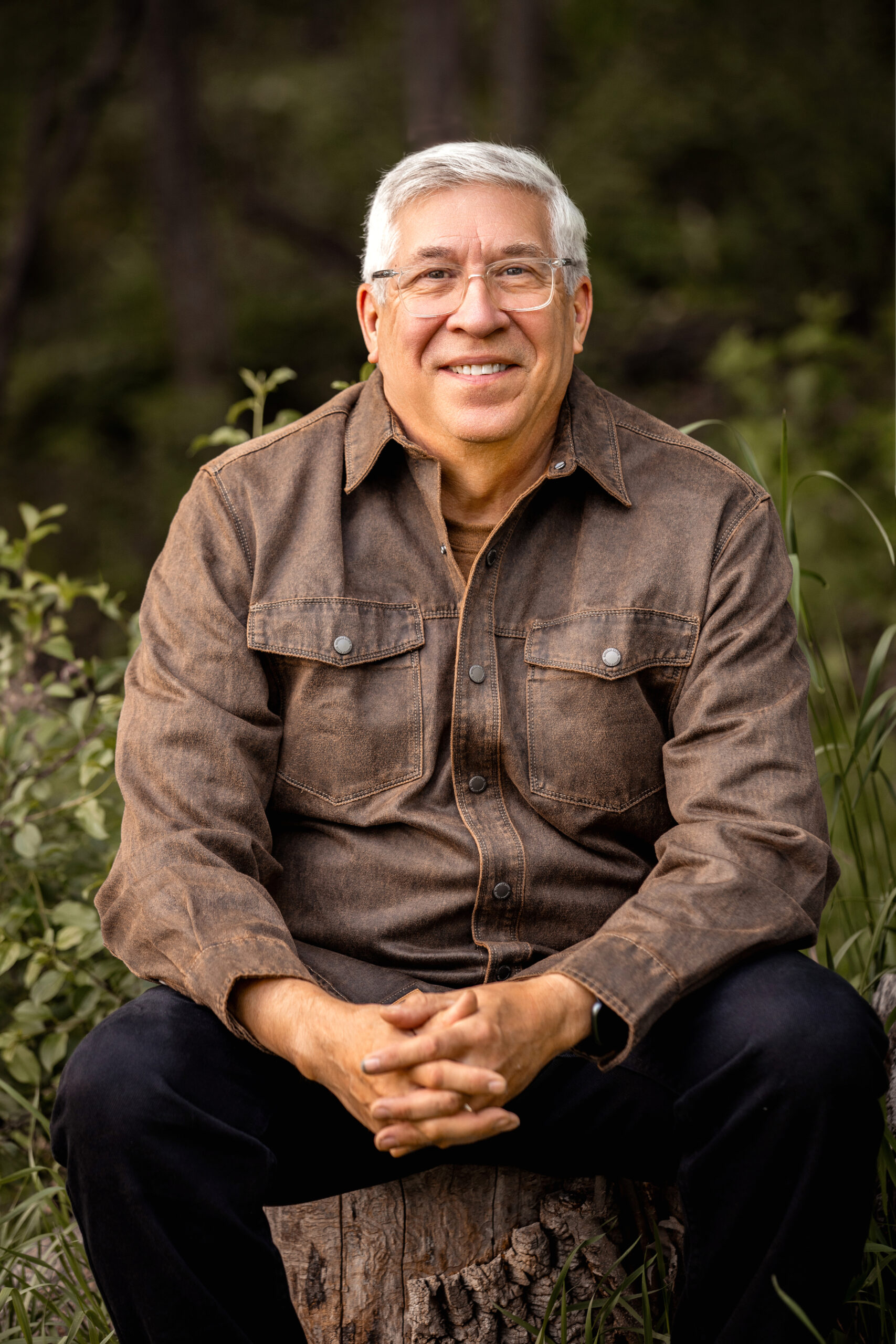 man sitting on log smiling