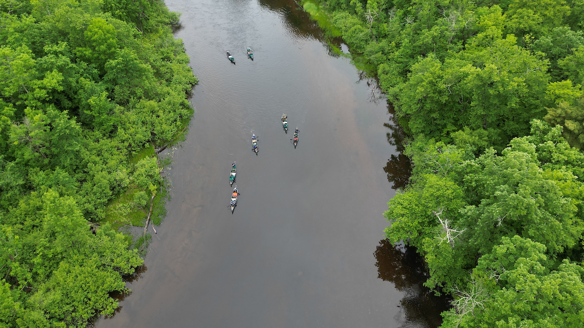 An aerial view of the seven canoes on the river