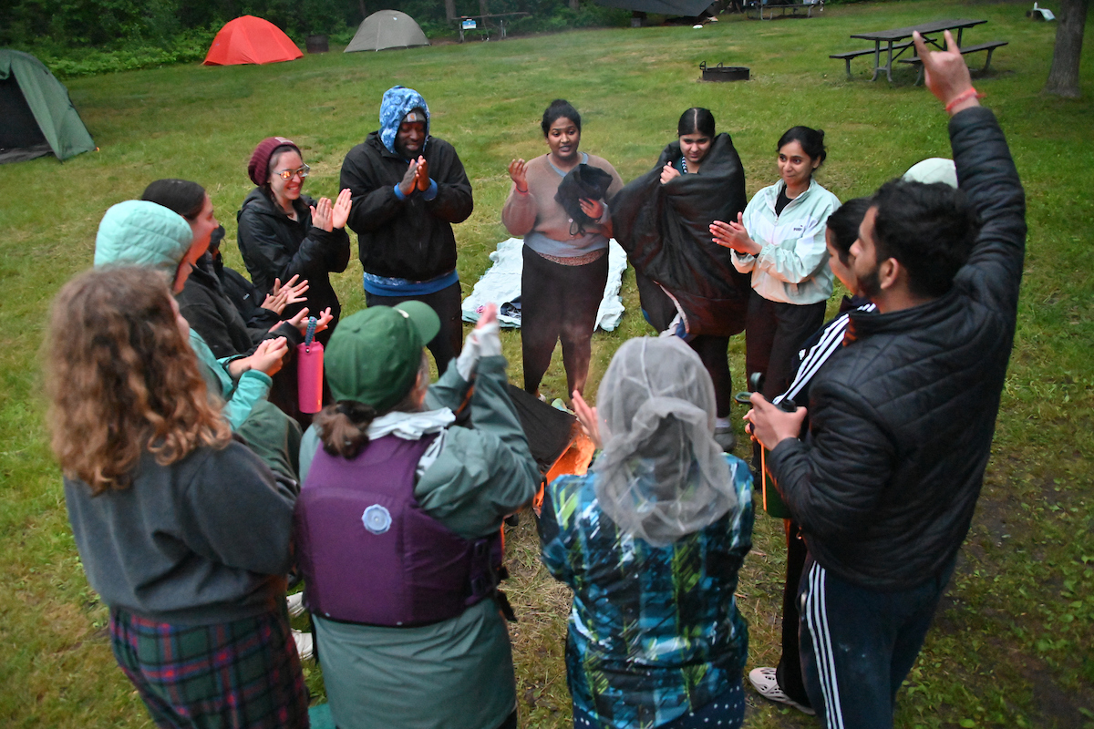 Students and staff warming up around the campfire.