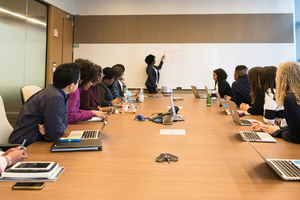 students around a conference table watching teacher