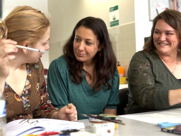 3 people talking while doing art therapy