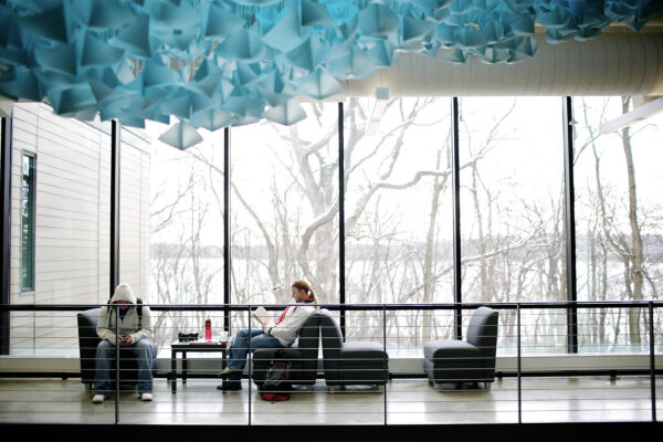 people sitting in a room with large windows