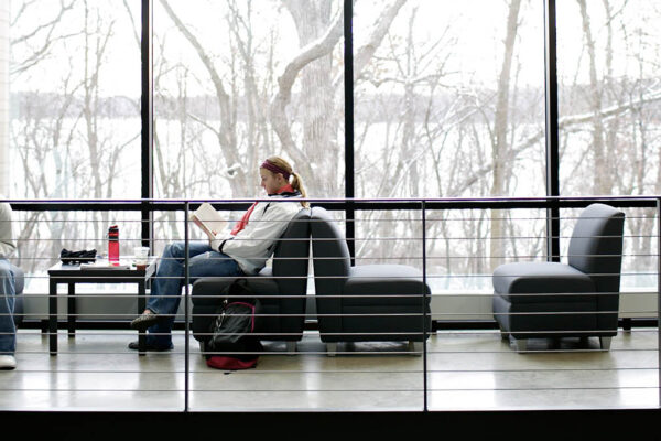 people sitting in a room with large windows