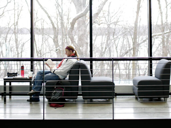 people sitting in a room with large windows