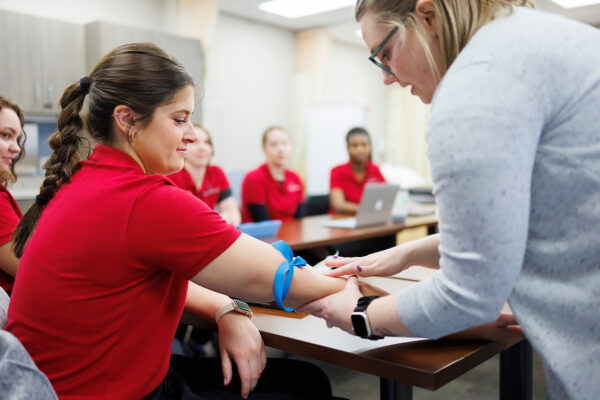 a person in a red shirt getting blood shot