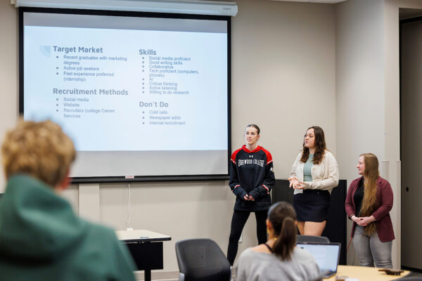 three students giving a presentation
