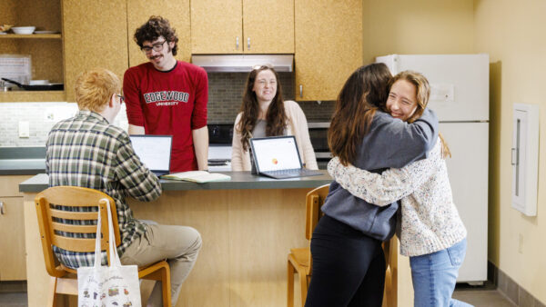 Students chatting and two students hugging