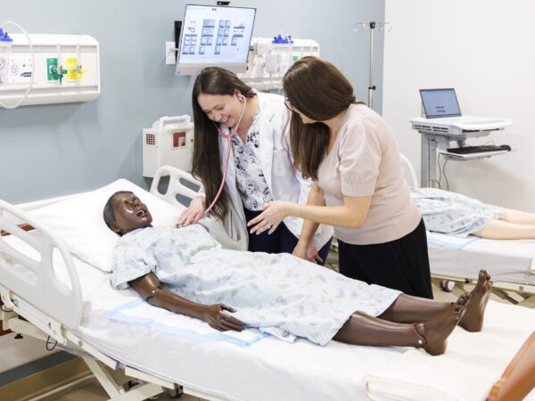 two nurses working on mannequin patient