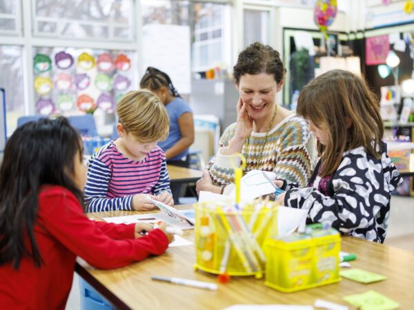 teacher at desk watching students