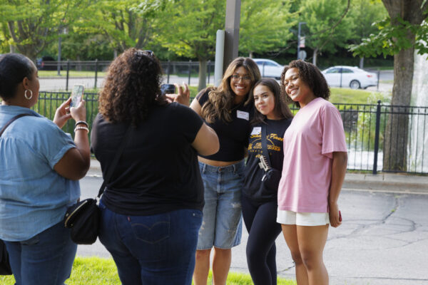 two moms taking pictures of three girls