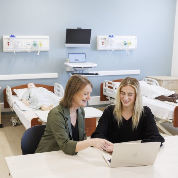 Two people looking at a laptop