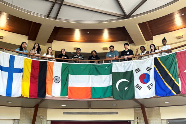 Students standing around country flags