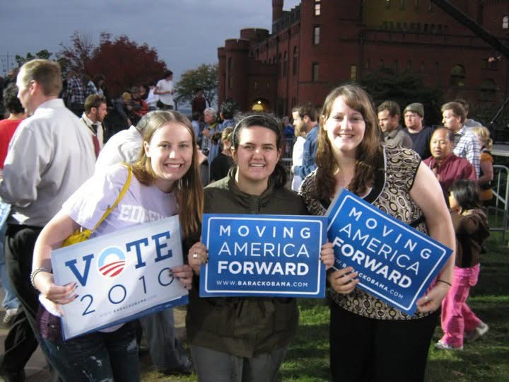 3 people holding signs