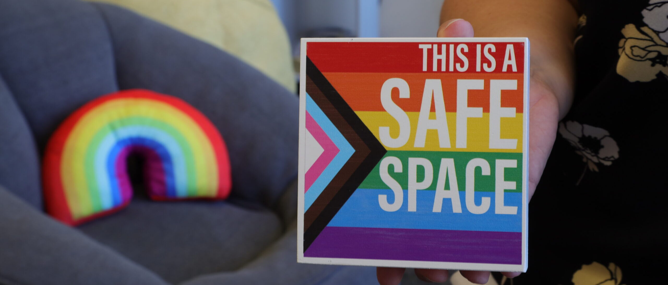 Woman holding image stating this is a safe place