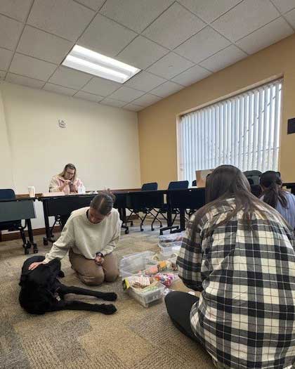 a photo of our facility dog in class with students in the Child Life program