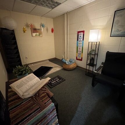 room with a book, rug, and carpet
