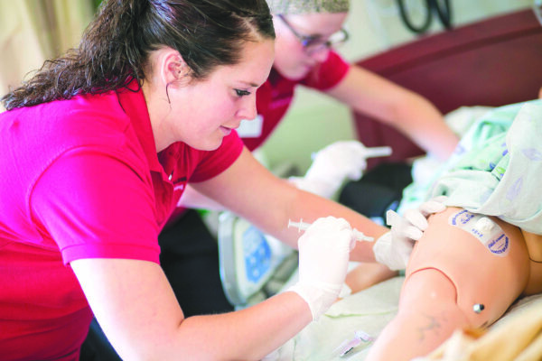 two health sciences students performing an examination