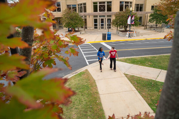 a couple of people walking on a sidewalk