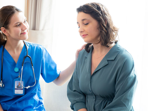 Caregiver caucasian young nurse woman comforting patient woman with stress and concern, doctor encourage and consoling patient with cancer while worry and sadness, medical and insurance.