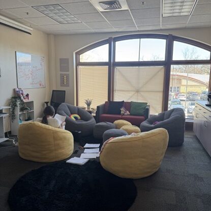 Room with chairs and someone sitting with back faced towards image