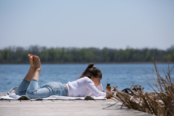 girl laying on deck reading book