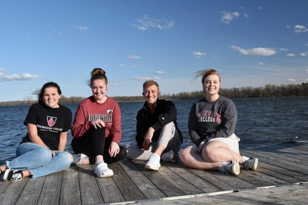 a group of women sitting on a dock