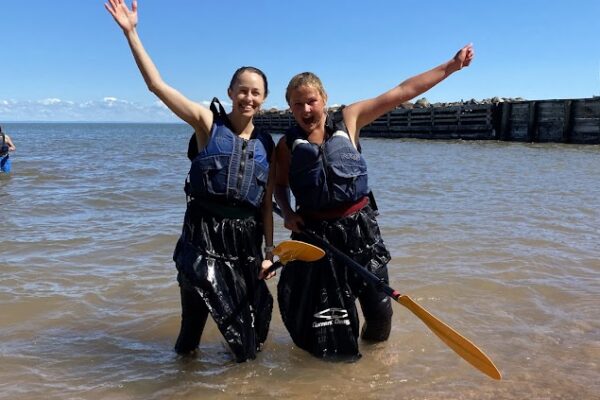 two woman with arms out