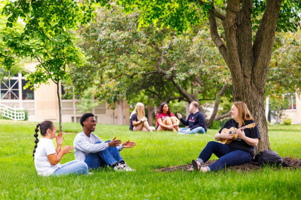 a group of people sitting on grass in a park